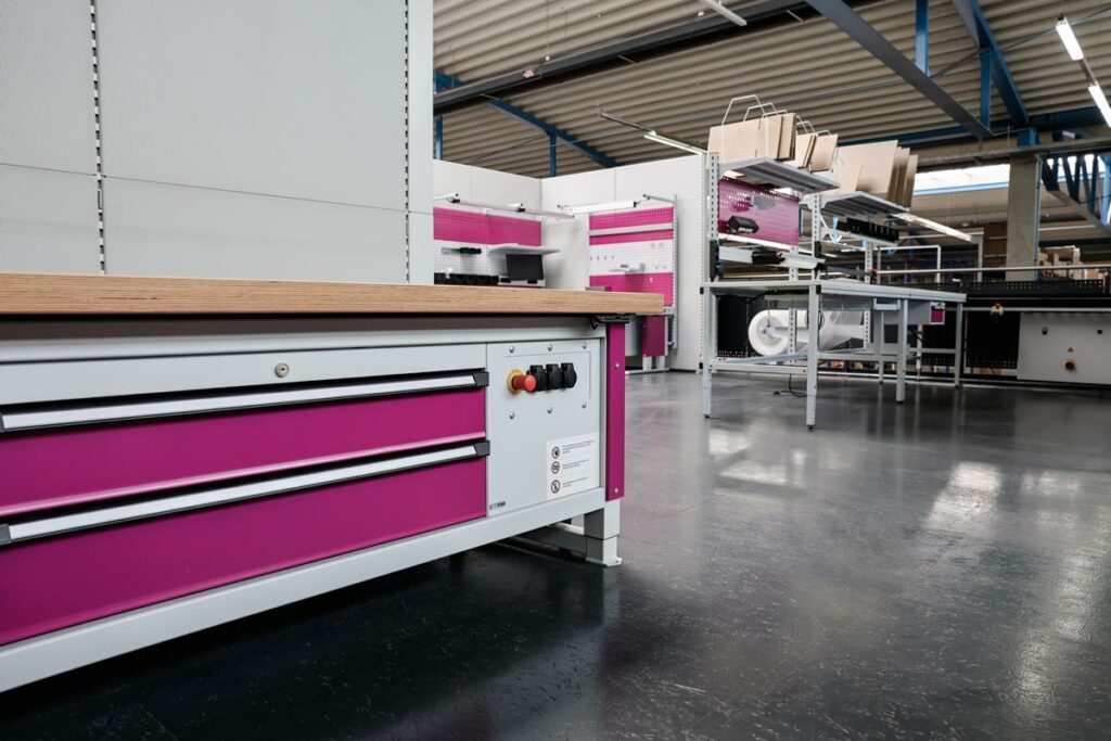 g-showroom02 Schwerlasttisch multi4power mit pinkfarbenen Schubladenfronten und Seitenteilen im Showroom