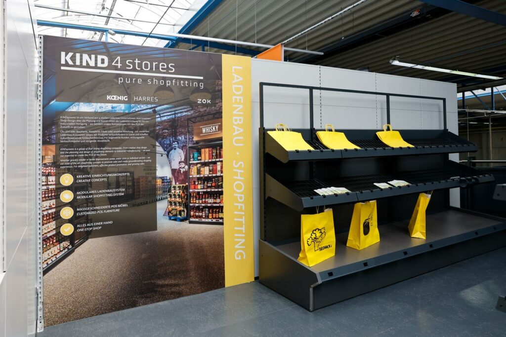 g-showroom05 KIND4stores-Bereich im Showroom mit großem Banner und Muster-Regal aus dem Ladenbau